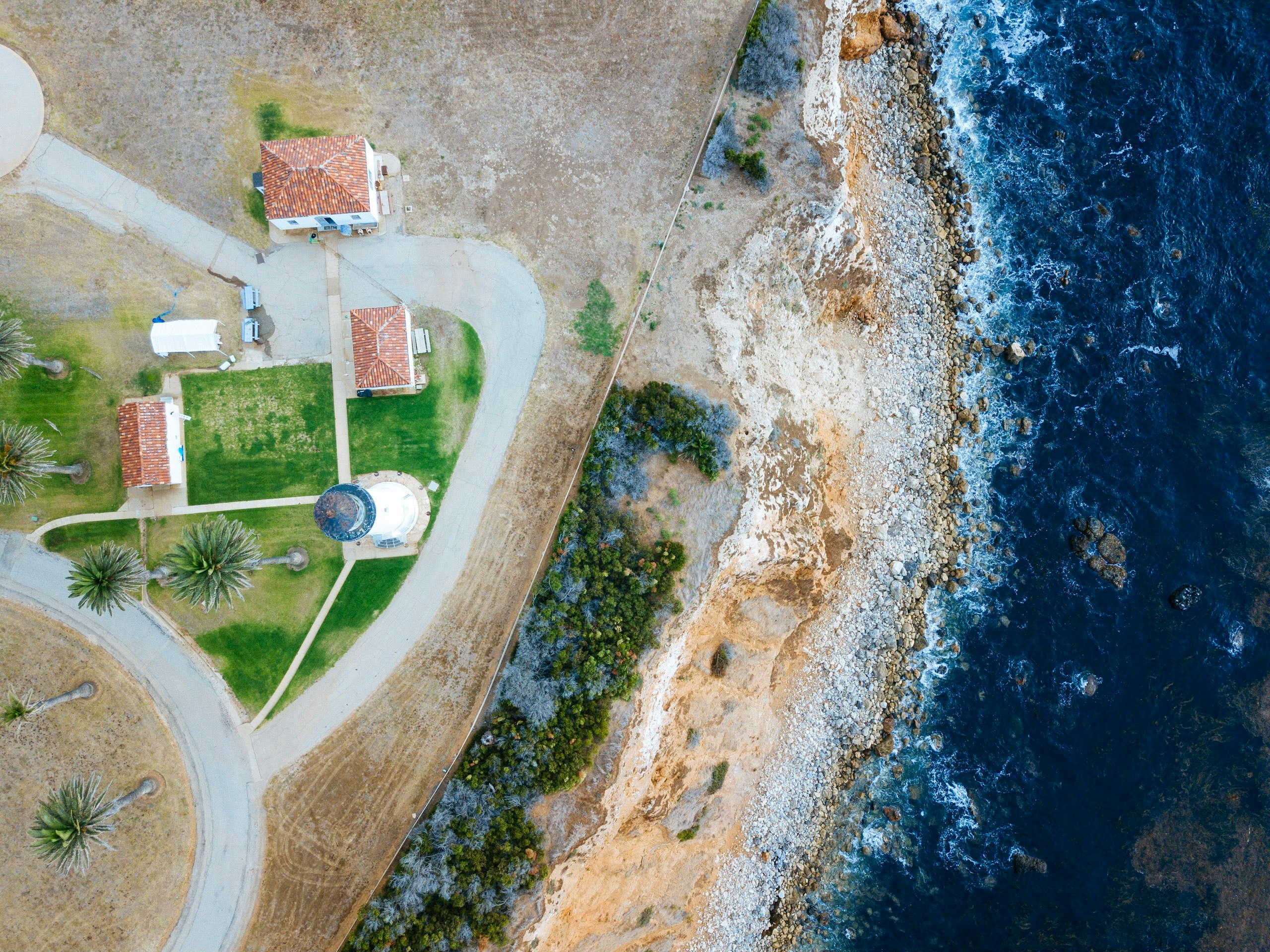 bird's-eye view photography of lighthouse nearby sea